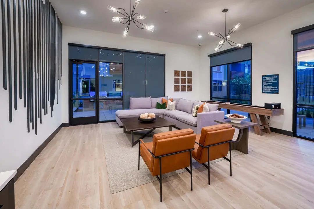 Resident lounge with sectional sofa and orange lounge chairs at Anton Viridian