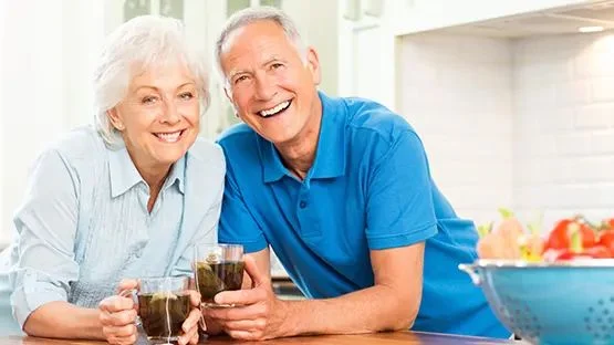 Two older adults sharing coffee at a kitchen counter